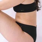 A woman wearing the Six Ada seamless underwear set in Black. Supportive and comfortable Bralette and high rise knicker style, suitable to wear for Maternity, breasfeeding, nursing bra, pregnancy and yoga.