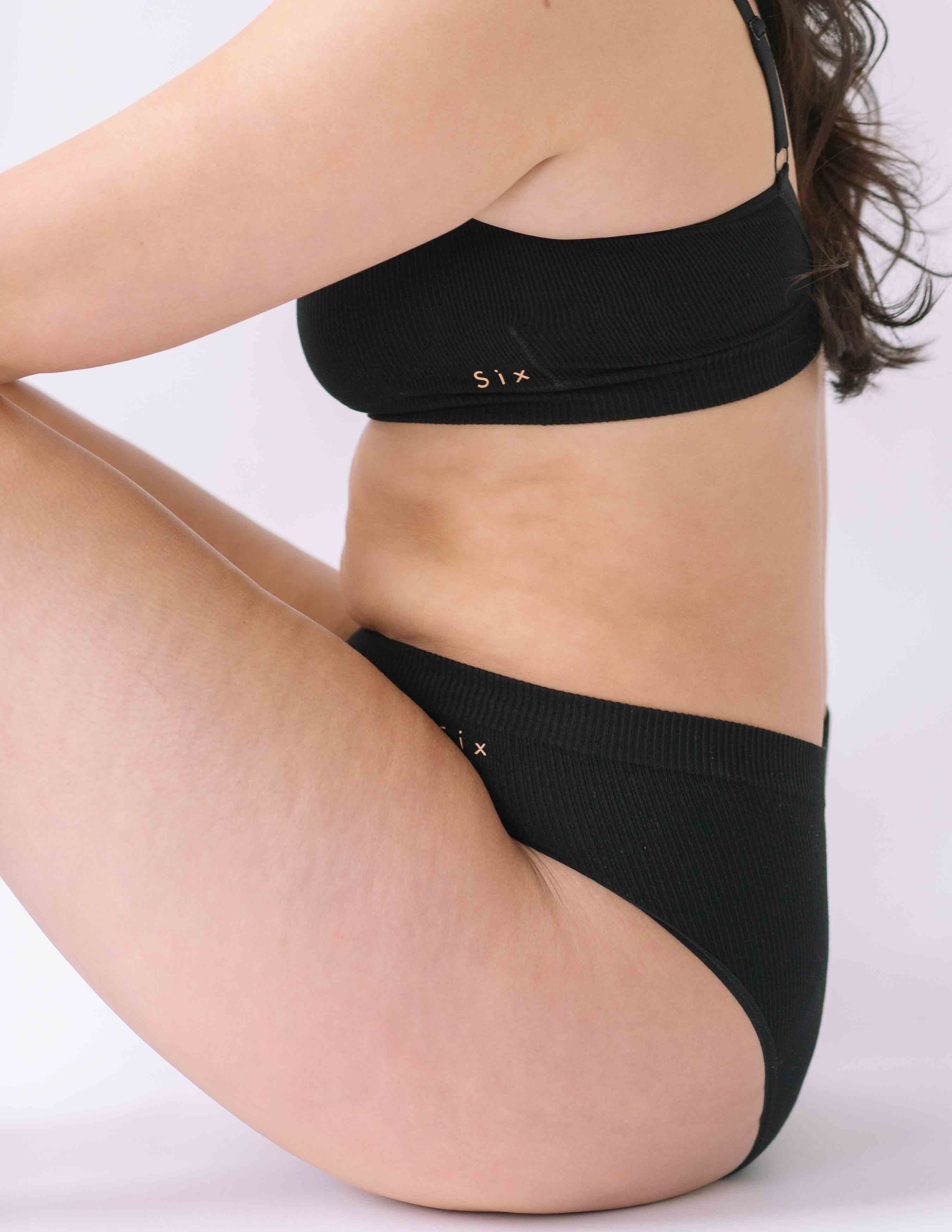 A woman wearing the Six Ada seamless underwear set in Black. Supportive and comfortable Bralette and high rise knicker style, suitable to wear for Maternity, breasfeeding, nursing bra, pregnancy and yoga.