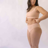 Woman wearing a set of Six seamless Ada underwear in Nude blush colour. A seamless supportive  and comfortable bralette  crop top and high waisted knicker suitable for post c-section, pregnancy and maternity Lingerie