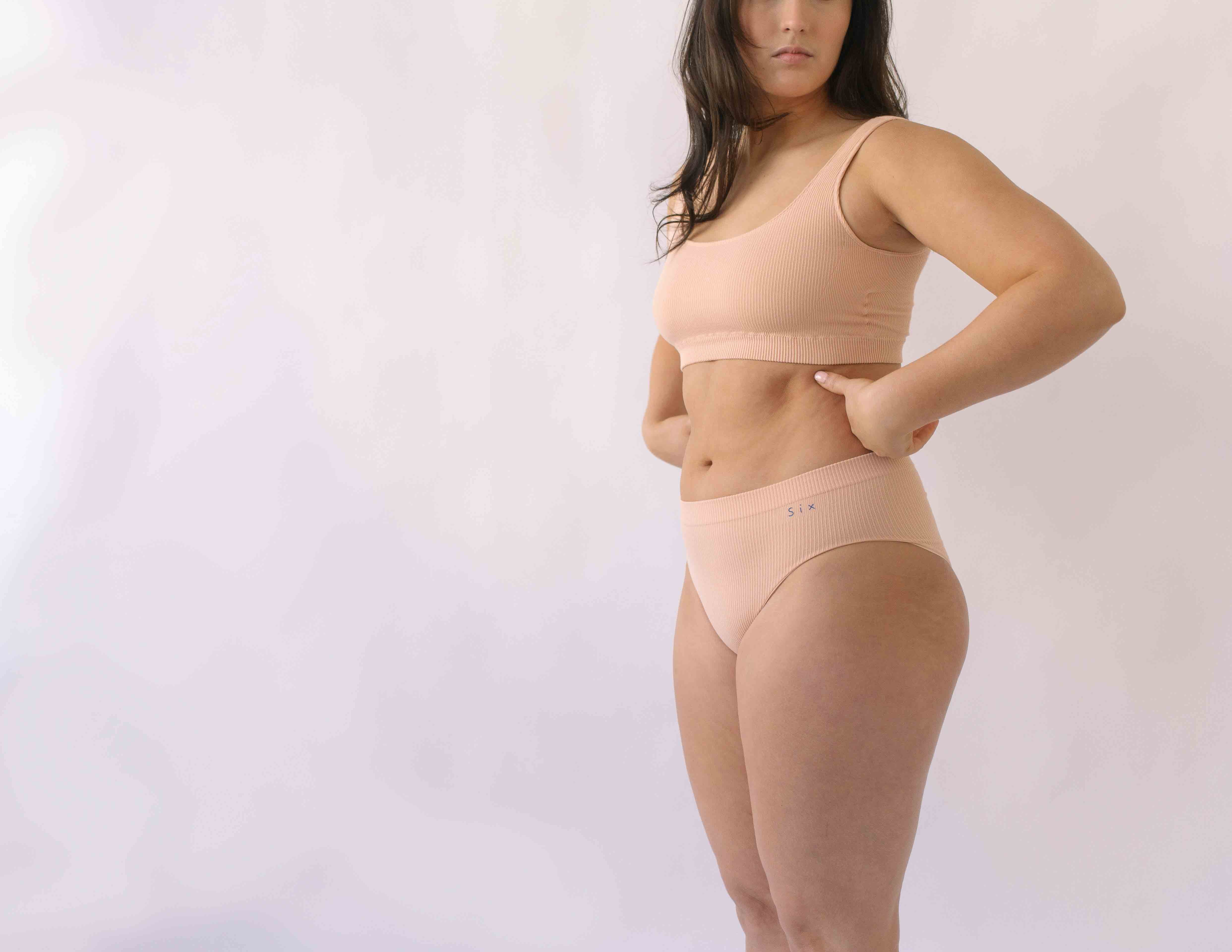 Woman wearing a set of Six seamless Ada underwear in Nude blush colour. A seamless supportive  and comfortable bralette  crop top and high waisted knicker suitable for post c-section, pregnancy and maternity Lingerie