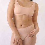 Woman wearing a set of Six seamless Ada underwear in Nude blush colour. A seamless supportive and comfortable bralette crop top and high waisted knicker suitable for post c-section, pregnancy and maternity Lingerie