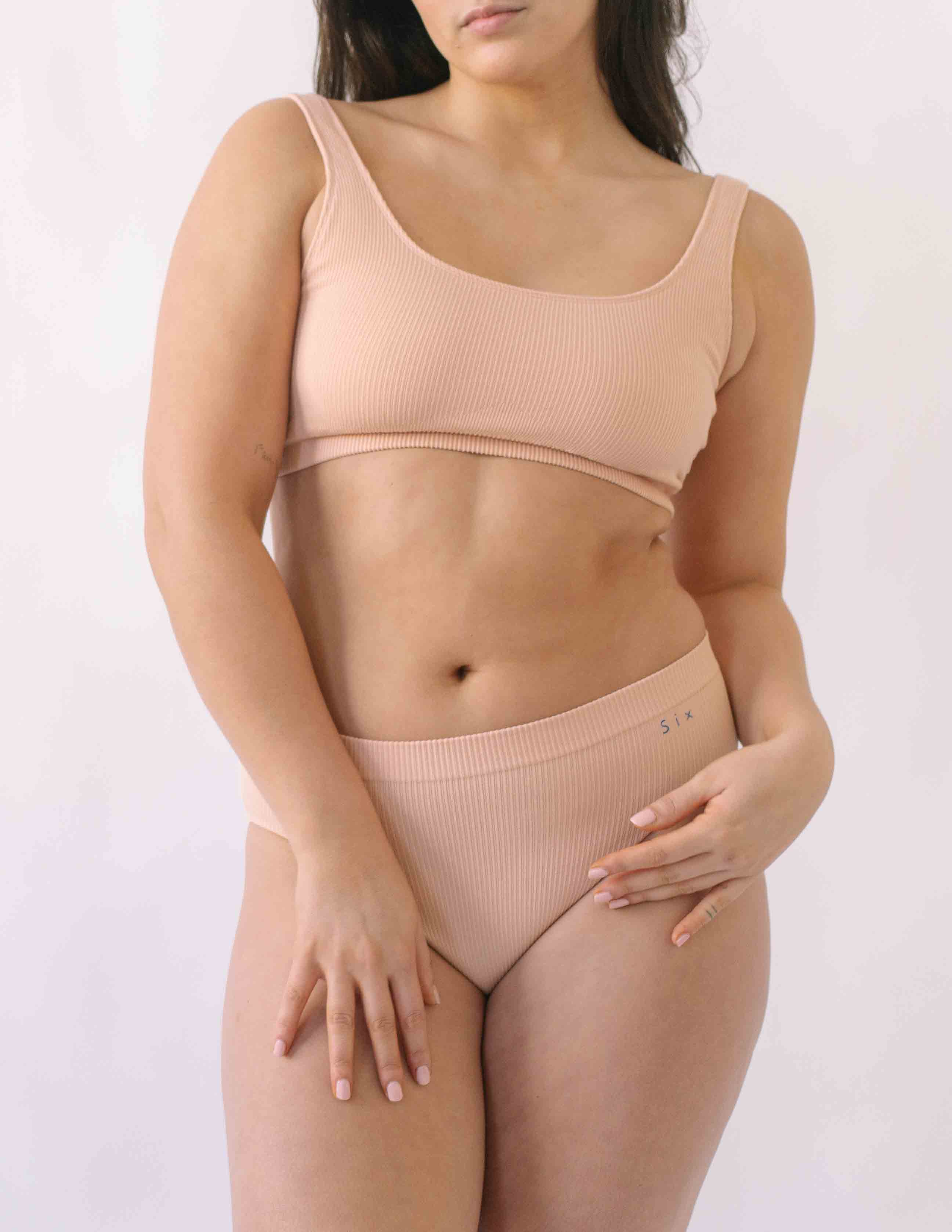 Woman wearing a set of Six seamless Ada underwear in Nude blush colour. A seamless supportive  and comfortable bralette  crop top and high waisted knicker suitable for post c-section, pregnancy and maternity Lingerie