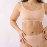 Woman wearing a set of Six seamless Ada underwear in Nude blush colour. A seamless supportive  and comfortable bralette  crop top and high waisted knicker suitable for post c-section, pregnancy and maternity Lingerie