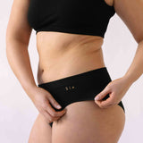 A woman wearing the Six Ada seamless underwear set in Black. Supportive and comfortable Bralette and high rise knicker style, suitable to wear for Maternity, breasfeeding, nursing bra, pregnancy and yoga.