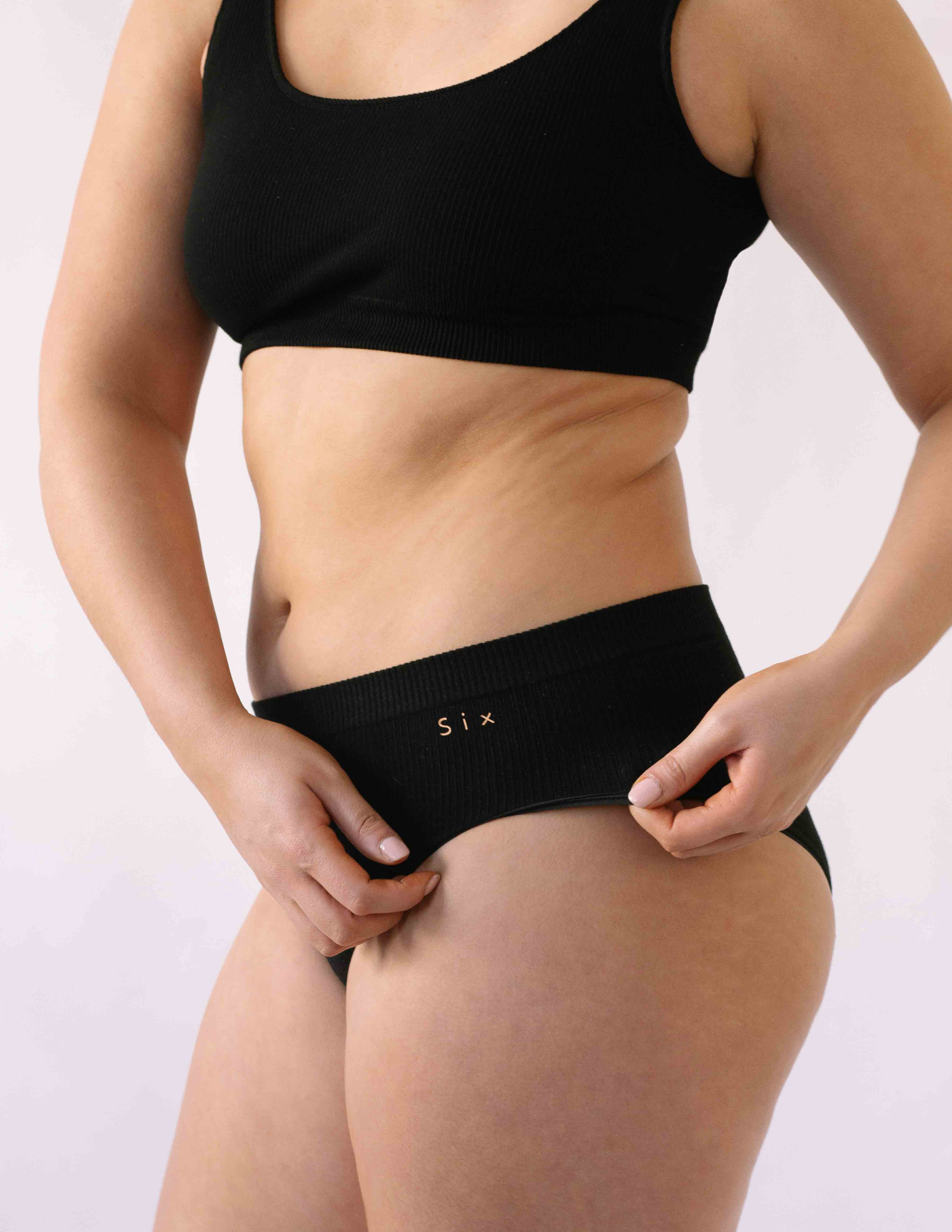 A woman wearing the Six Ada seamless underwear set in Black. Supportive and comfortable Bralette and high rise knicker style, suitable to wear for Maternity, breasfeeding, nursing bra, pregnancy and yoga.