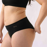 A woman wearing the Six Ada seamless underwear set in Black. Supportive and comfortable Bralette and high rise knicker style, suitable to wear for Maternity, breasfeeding, nursing bra, pregnancy and yoga.