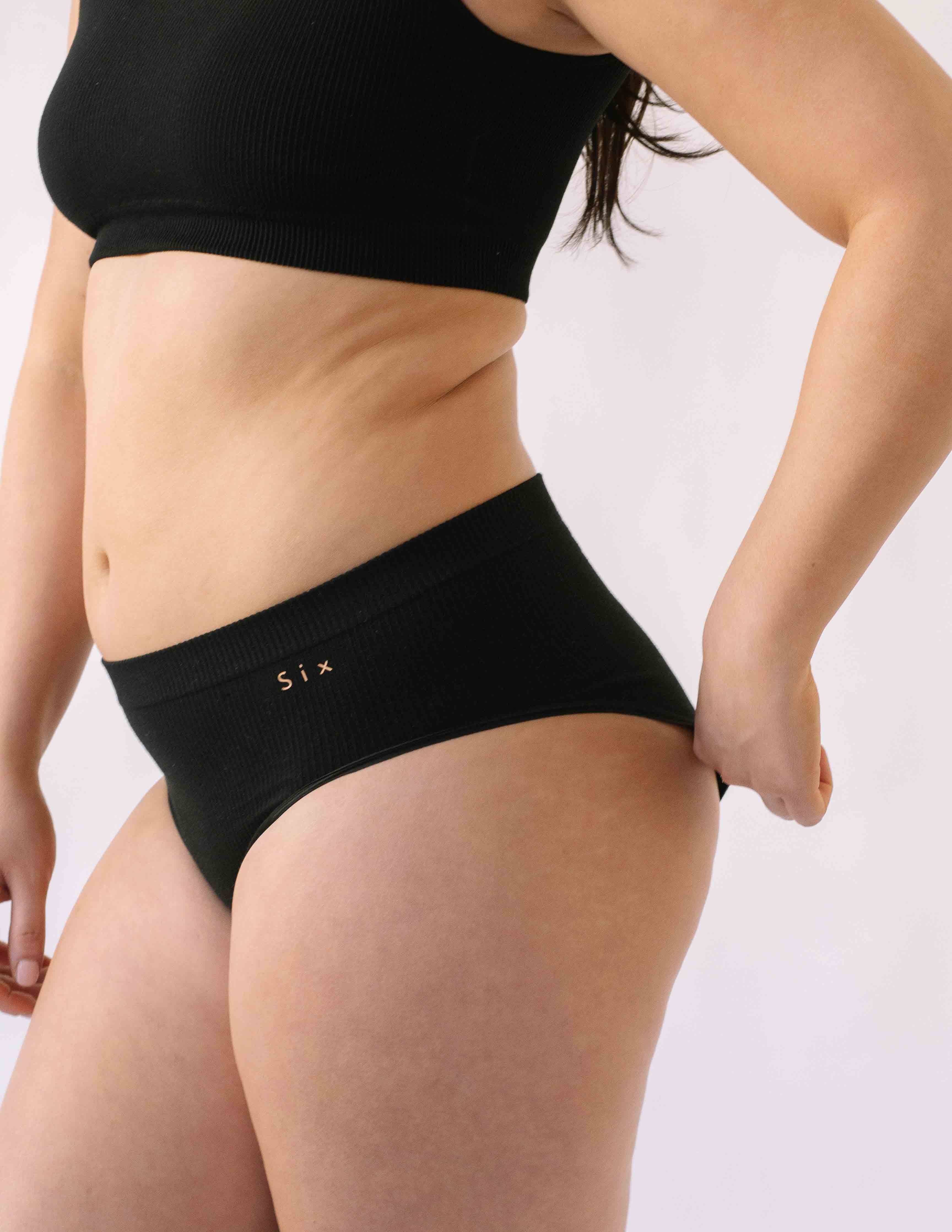 A woman wearing the Six Ada seamless underwear set in Black. Supportive and comfortable Bralette and high rise knicker style, suitable to wear for Maternity, breasfeeding, nursing bra, pregnancy and yoga.