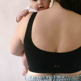 Woman holding a baby wearing the Six Maya Seamless comfortable and supporitve Bralette in Black