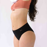 Woman wearing Six Ada deep seamless knicker., suitable to wear throughout pregnancy and after a C section with a nude coloured Cotton rib bralette.