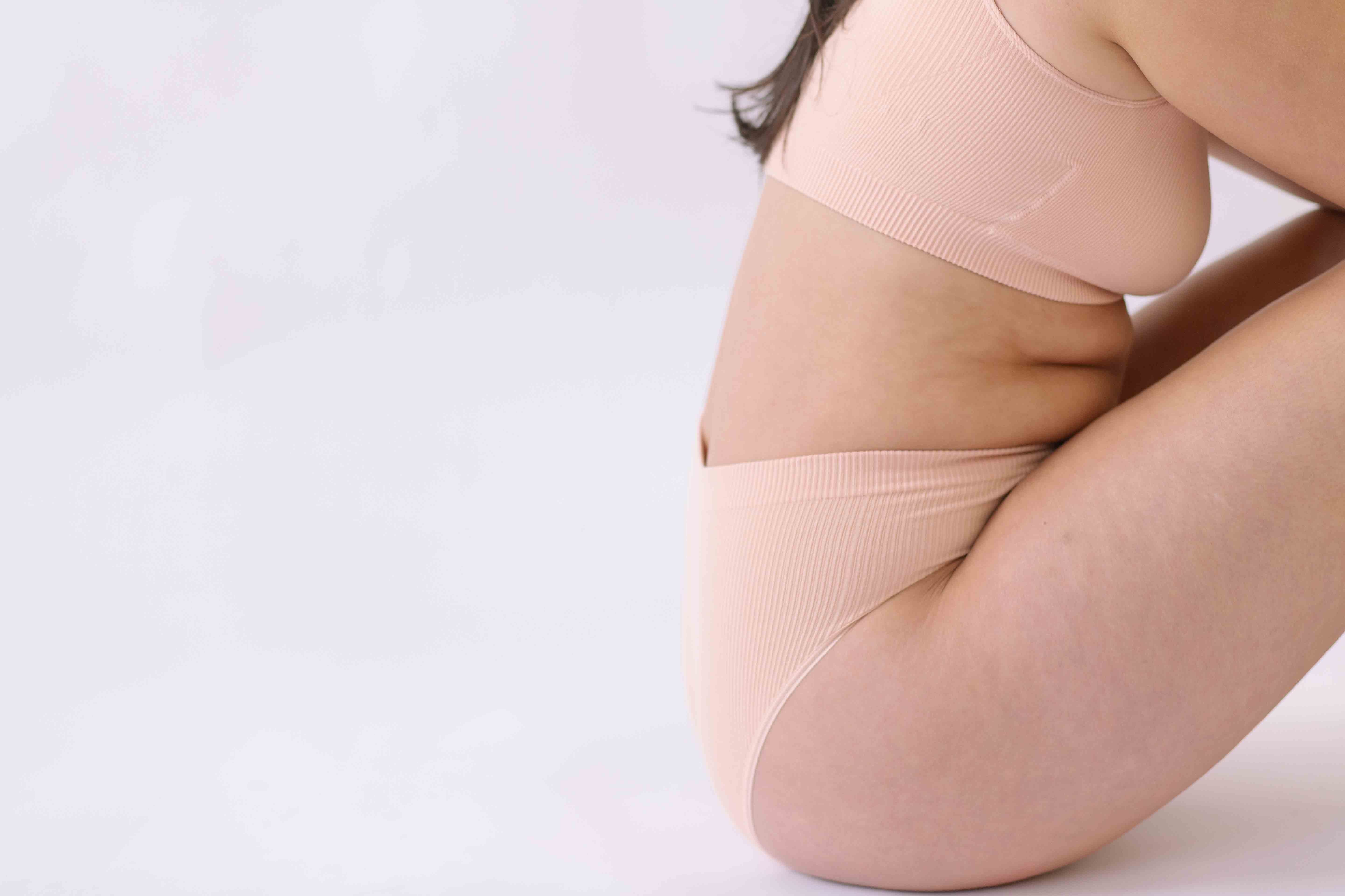 Woman wearing a set of Six seamless Ada underwear in Nude blush colour. A seamless supportive  and comfortable bralette  crop top and high waisted knicker suitable for post c-section, pregnancy and maternity Lingerie